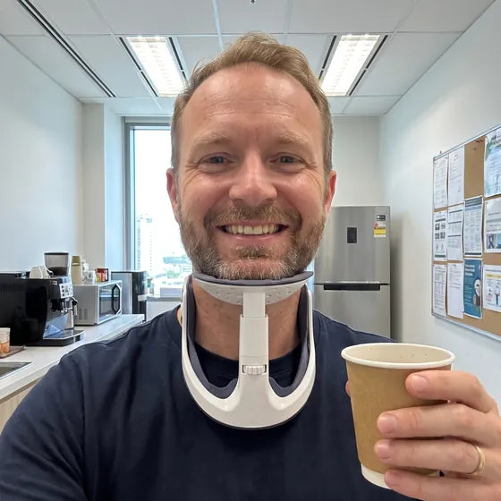 Daniel M. at his office, wearing NAPE and holding a coffee cup