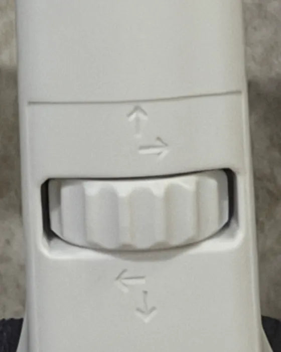 Close-up of the NAPE lift dial set into the white column, with small arrows above and below it