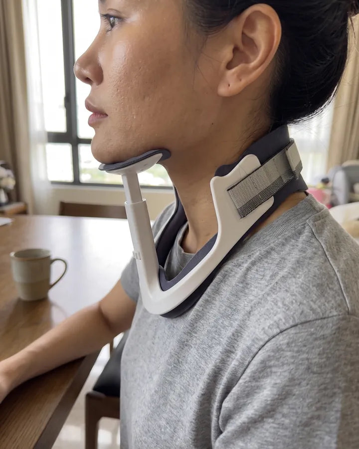 Side profile of a person wearing NAPE: the chin rests on a padded support, a column runs down from it, and the base rests on the upper chest